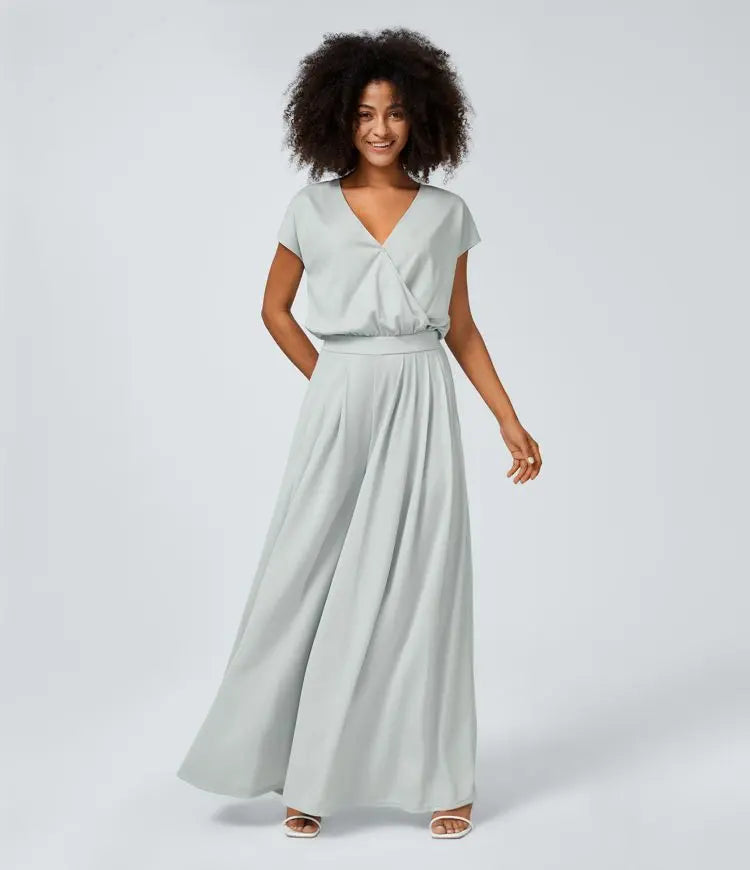 Neformální overal s V-výstřihem, širokými plisovanými nohavicemi, krátkým rukávem, boční kapsou a splývavou texturou